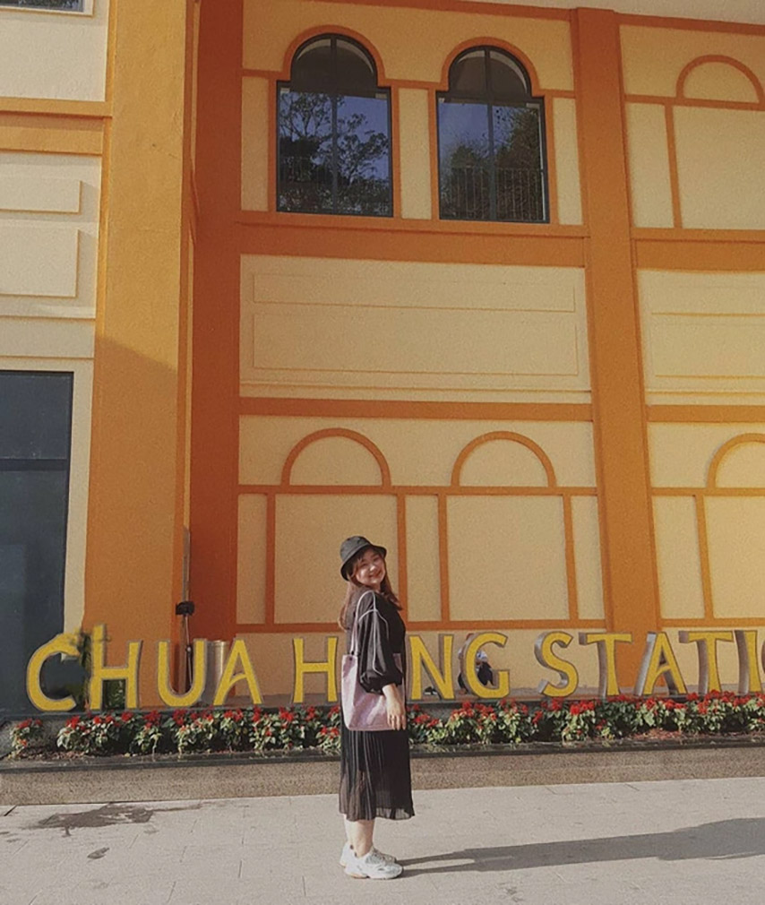 Nữ du khách trẻ chụp hình cùng biển hiệu “Chua Hang station”