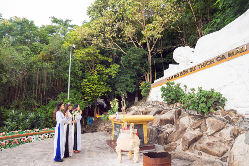 Du khách cầu nguyện trước dáng nằm kiết tường của tượng Phật