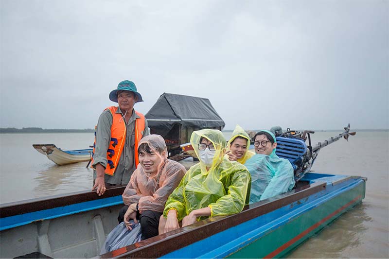 Du khách ngồi cano ra đảo Nhím vào một ngày mưa